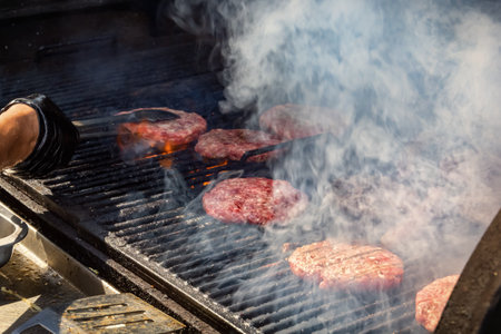 Hamburger cutlets are fried in smoke on a grill grateの写真素材