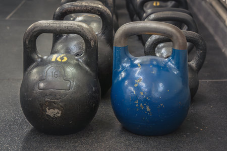 Sports kettlebells of different weights stand on the floor in the gym. close-upの写真素材
