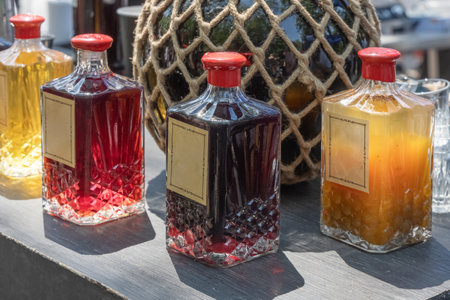 Sale of bottles of wine or tinctures against the background of a large glass bottle in a rope braid. street trading. copy spaceの写真素材