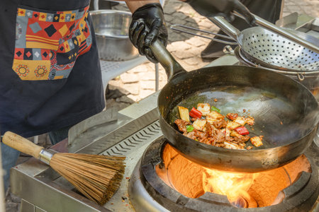 Cooking Asian food from meat and vegetables in a wok over an open fire. street food. fast foodの写真素材