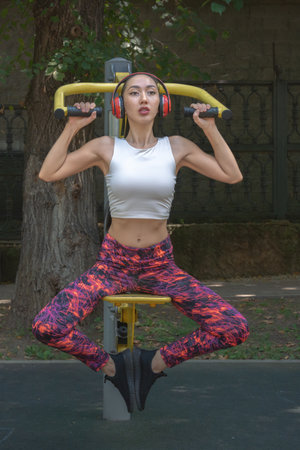 Beautiful Asian girl doing sports on the trainer in the park. Fitness. Healthy lifestyleの写真素材