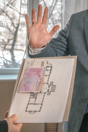 Man in a suit and tie refuses to take a folder with documents and attached Euro banknotes. Refusal...