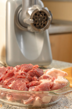 Pieces of raw meat are prepared for scrolling in an electric meat grinder. Cookingの写真素材