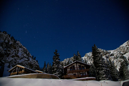 Winter mountains at night. Alpine cliffs in the moonlight and the constellation of Orionの写真素材