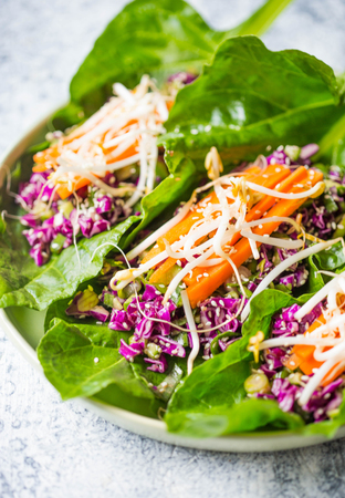 Vegan salad in leaf with avocado, sweet potato, beans, herbs, spinat on concrete rustic background. Vegan/vegetarian food. Making healthy saladの写真素材