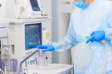 Professional quality medicine. Anesthesiologist prepares equipment for surgeryの写真素材