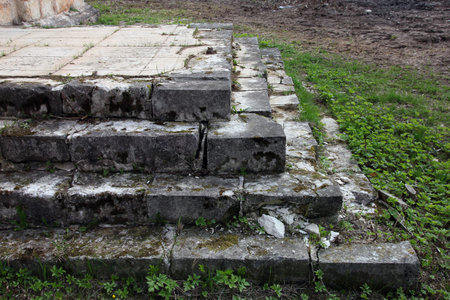 old medieval grey stone steps of the orthodox church covered with green moss and grass, near Staritsa, Russiaの写真素材
