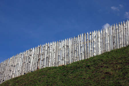 the wooden palisade on the green grass shaft  and blue sky as a background, Torzhok, Russiaの写真素材