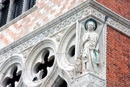 fragment of main facade of Doge's Palace in Venice with statue on the cornerのeditorial素材