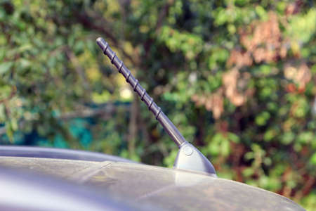 black car foldable antenna on car roof foreground closeupの写真素材