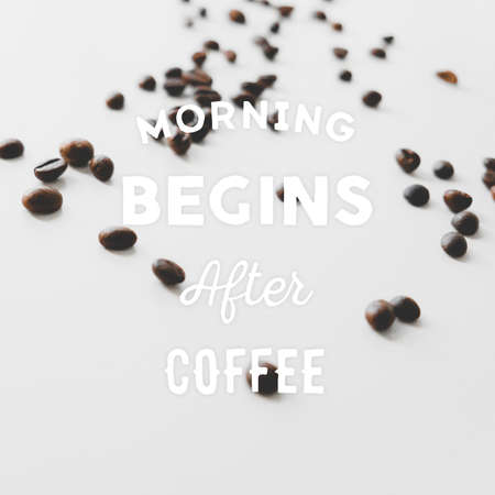 Coffee beans scattered on the table and  hand drawn quote Morning begins after coffeeの写真素材