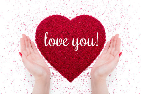 On the red heart made of sand written love youの写真素材