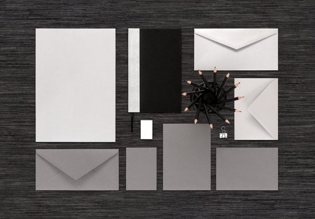 Top view of template for corporate branding identity for design presentation or portfolio on black table. Mockup includes paper, envelopes, business card, notebook, pencils, eraser, binder clip.の写真素材