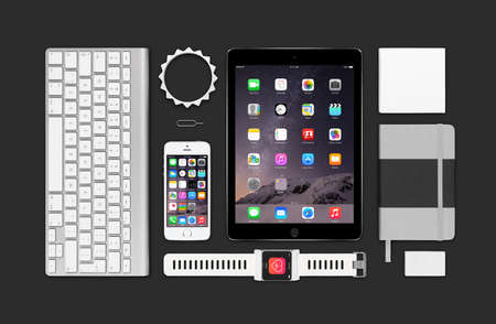 Varna, Bulgaria - February 09, 2015: Top view of Apple products mockup. Consists of ipad air 2, iphone 5s, keyboard, smartwatch concept, notebook, eraser, bracelet, reminder.のeditorial素材