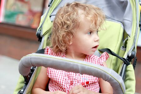 Surprised girl in the pram looking away  の写真素材