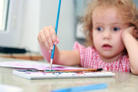 Creative little girl draws in classroom  Budding artist の写真素材