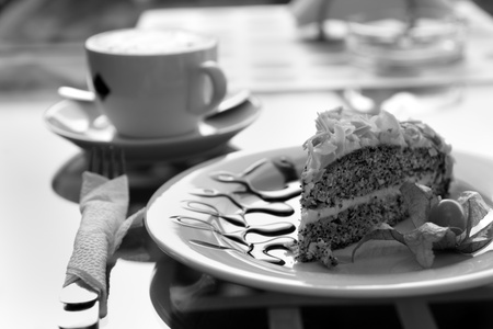 Cappuccino and poppy seed cake on cafe table outdoors at sunny morning.の写真素材