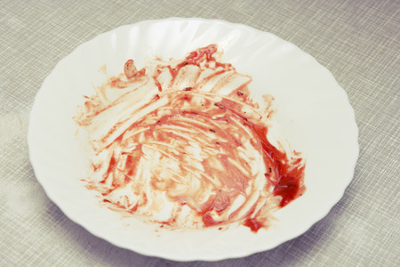 Tomato sauce smeared on a plate   Dirty plate on the tableの写真素材