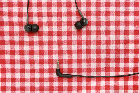 Headphones on a red bed sheet  Headphones on a textile 