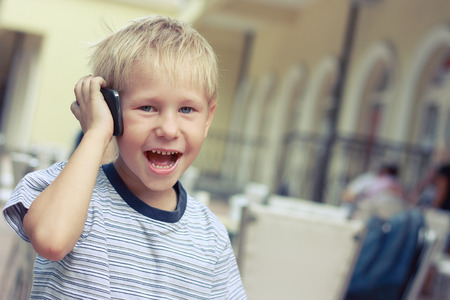 Boy speaks to a mobile phone, tinted photo.の写真素材