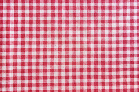 Red picnic tablecloth background. Red and white checkered fabric texture.の写真素材