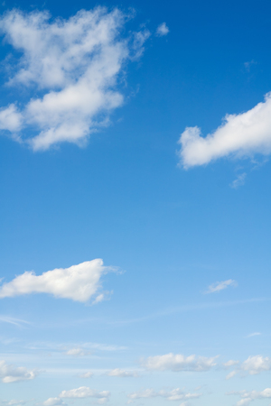 Blue sky with clouds over horizon. White clouds flying against blue sky.の写真素材