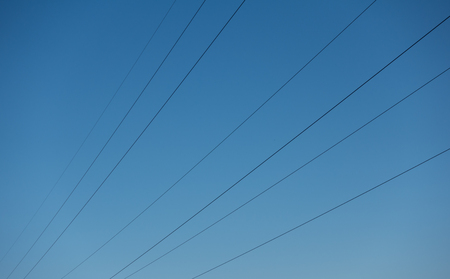 High voltage power wires against sky, network. Blue clear sky and electric cables.の写真素材