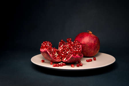 red pomegranate on a plate on a dark backgroundの写真素材
