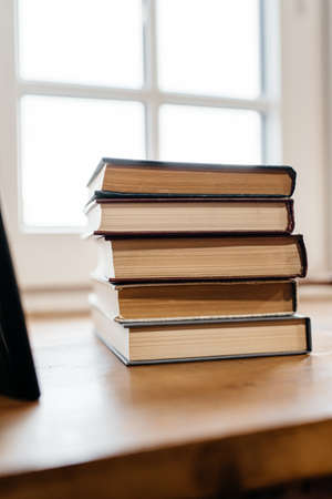 a stack of old books on the windowsill. Side viewの写真素材