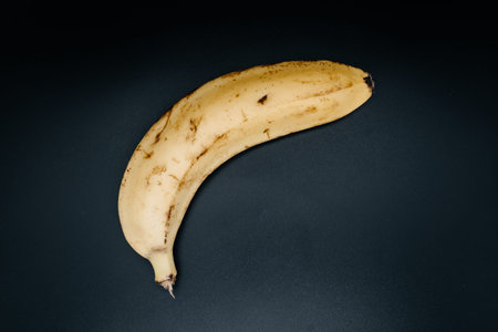 Yellow banana on dark background close up. View from aboveの写真素材