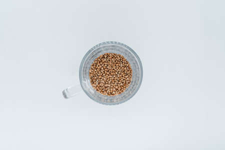 Buckwheat in a transparent glass on a white background. View from aboveの写真素材
