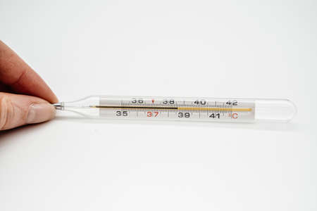 Thermometer in hand close-up with a temperature of 38.6. Side viewの写真素材