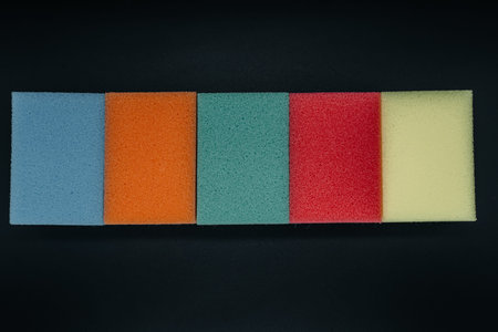 Sponges for washing dishes on a dark background close-up. View from above