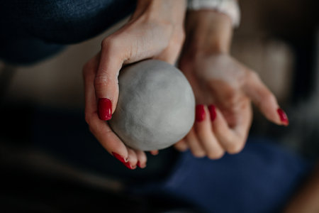 Ball of gray clay in handの写真素材