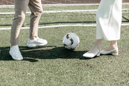 Newlyweds playing ball on the football fieldの写真素材