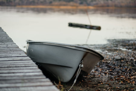 Old wooden pier on the lake with a tied boat