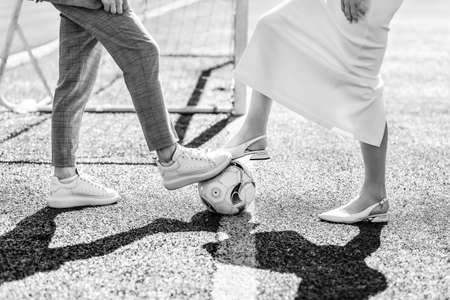 Newlyweds playing ball on the football fieldの写真素材