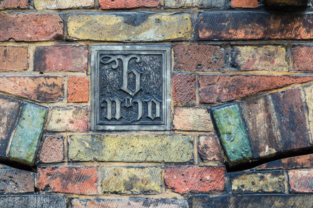 Art decor plate on old brickwork wall in Brugge, Belgiumの写真素材