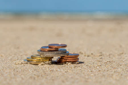 Business coins at holiday in the sand on the beach, North Seaの写真素材