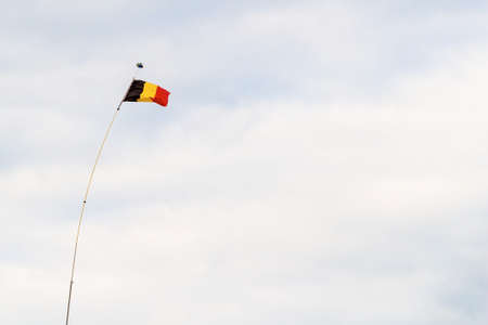 Belgium flag at wind on cloudy sky, Flandersの写真素材