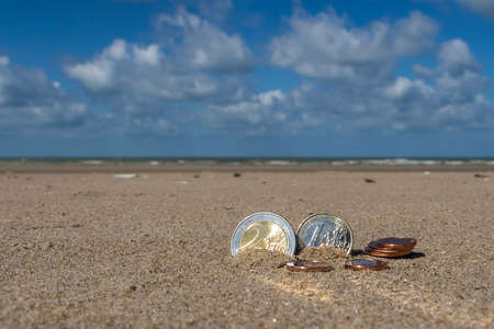 Business coins at holiday in the sand on the beach, North Seaの写真素材