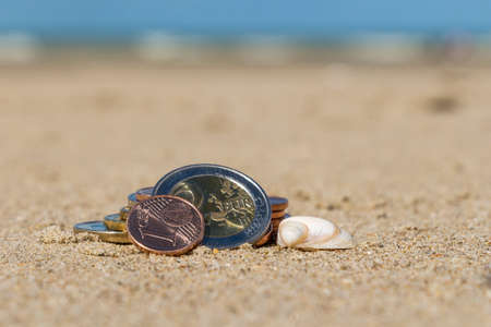 Business coins at holiday in the sand on the beach, North Seaの写真素材