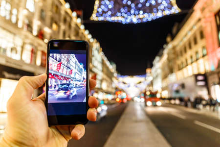 Taking photo of Christmas London on mobile phone, Englandの写真素材