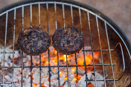 Cooking burgers on barbecue oven in the garden