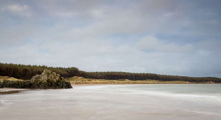 A view of Ynys Llanddwyn,  a small tidal island off the west coast of Anglesey, northwest Wales, UKの写真素材