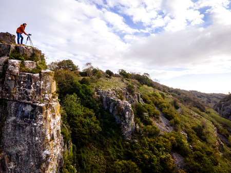 Photographer taking shots of limestone Cheddar Gorge in the Mendip Hills, near the village of Cheddar, Somerset, Englandの写真素材