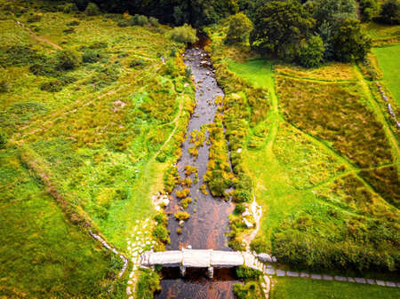 A view of Postbridge Clapper Bridge in Dartmoor National Park is a vast moorland in the county of Devon, in southwest England, UKの写真素材