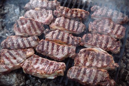 Sliced portions of hot and juicy steak is cooked on the grill, and around the steak-smoke.の写真素材