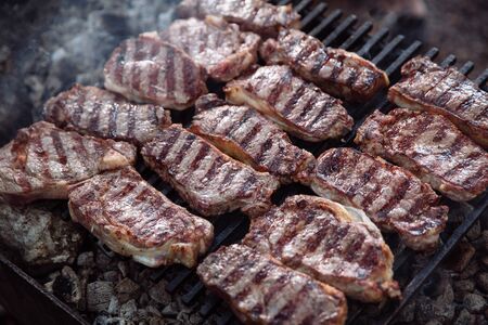 Sliced portions of hot and juicy steak is cooked on the grill, and around the steak-smoke.の写真素材