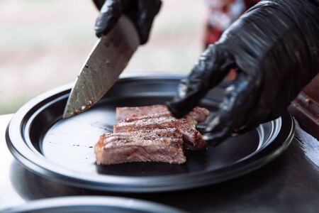 Chef hands slicing juicy steak with a knife.の写真素材